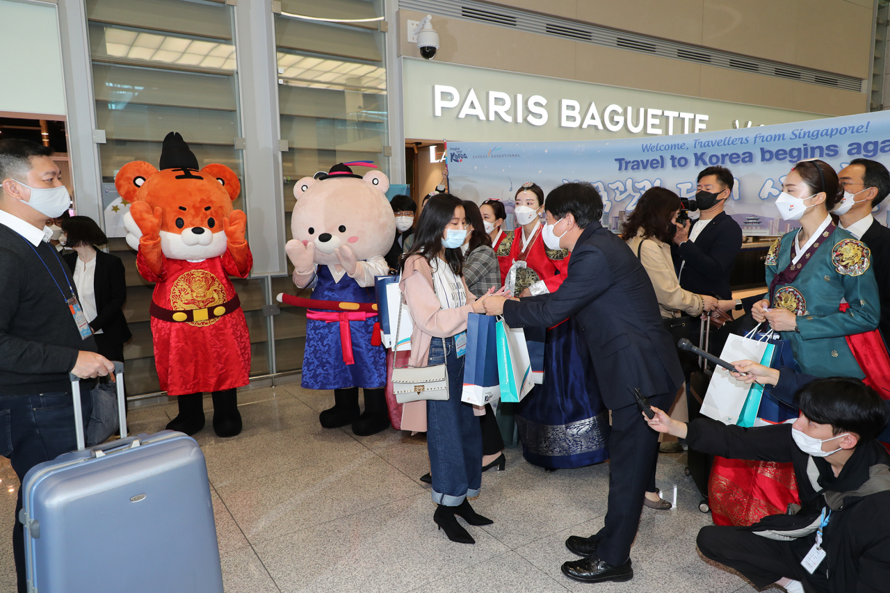 첫 손님. 15일 인천공항으로 입국한 싱가포르 여행객들이 안영배 한국관광공사 사장 등의 환대를 받고 있다.