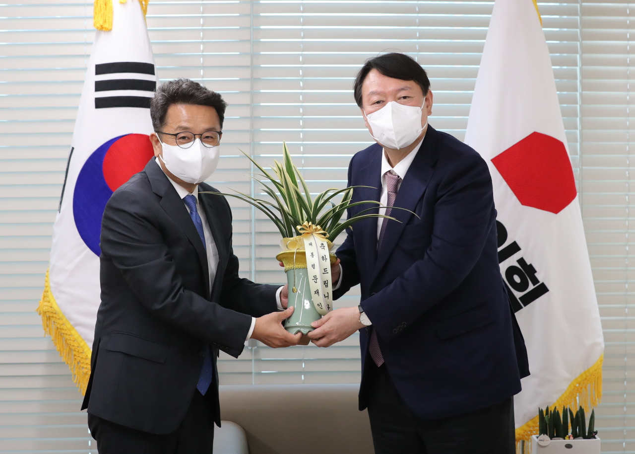 윤석열 국민의힘 대선 후보가 15일 오후 서울 영등포 국민의힘 당사에서 이철희 청와대 정무수석으로부터 문재인 대통령의 축하 난을 전달받고 있다. [헤럴드경제=이상섭 기자]