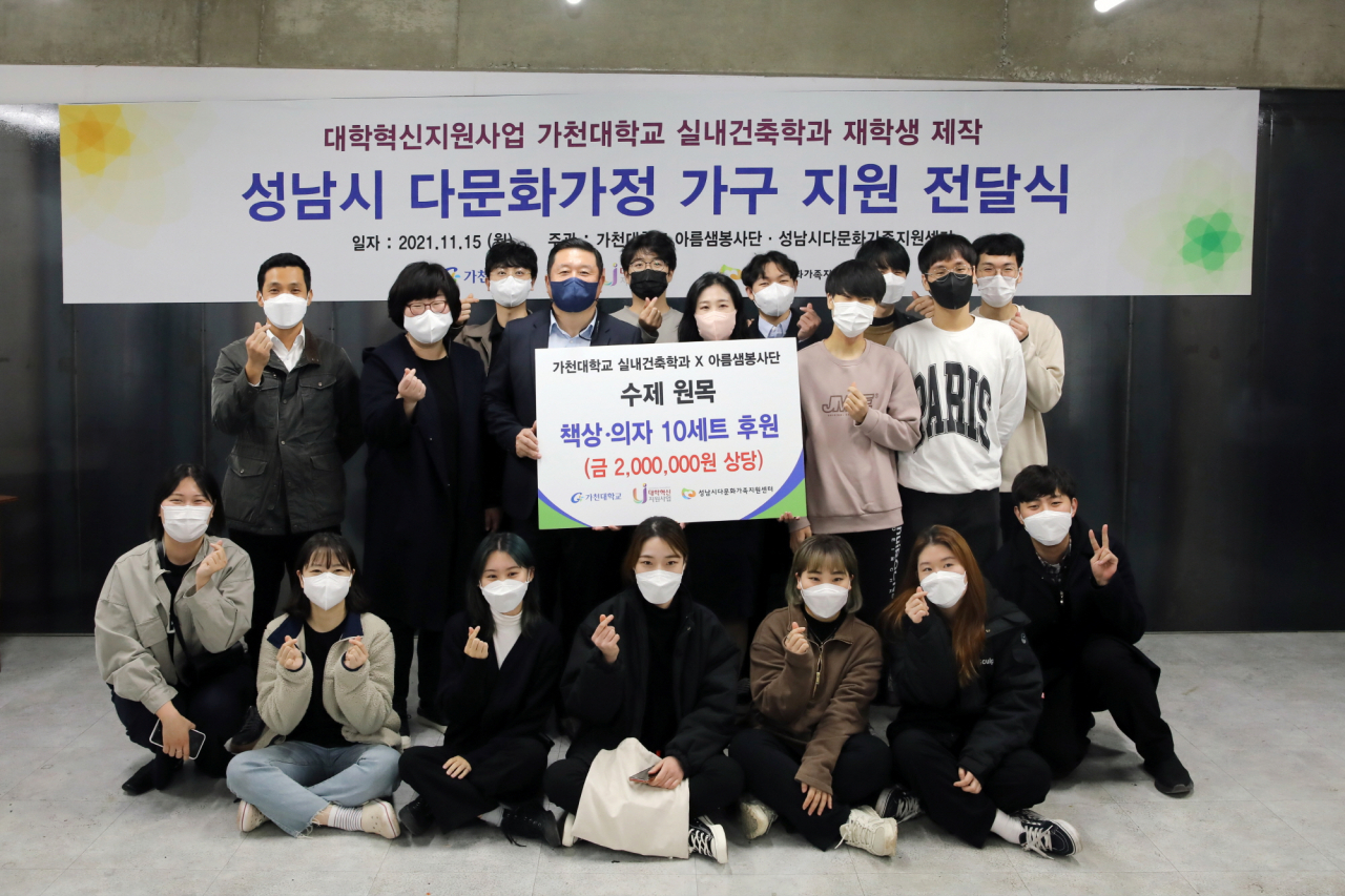 가천대 실내건축학과 학생들이 다문화가정 가구전달에 앞서 직접 제작한 의자와 책상 앞에서 기념촬영하고 있다.[가천대 제공]