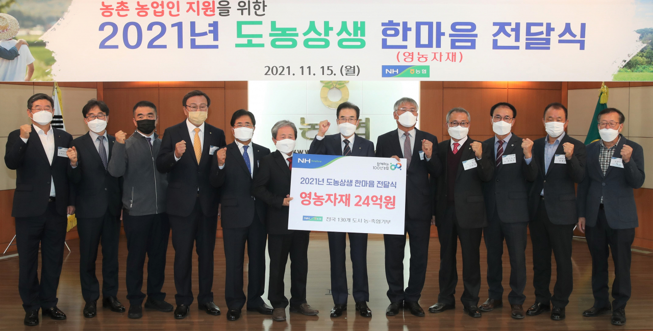 이성희(가운데) 농협중앙회장이 15일 강원 춘천 농협 강원지역본부에서 열린 '2021년 도농상생 한마음 전달식'에서 참석자들과 기념 촬영하고 있다.[농협중앙회 제공]