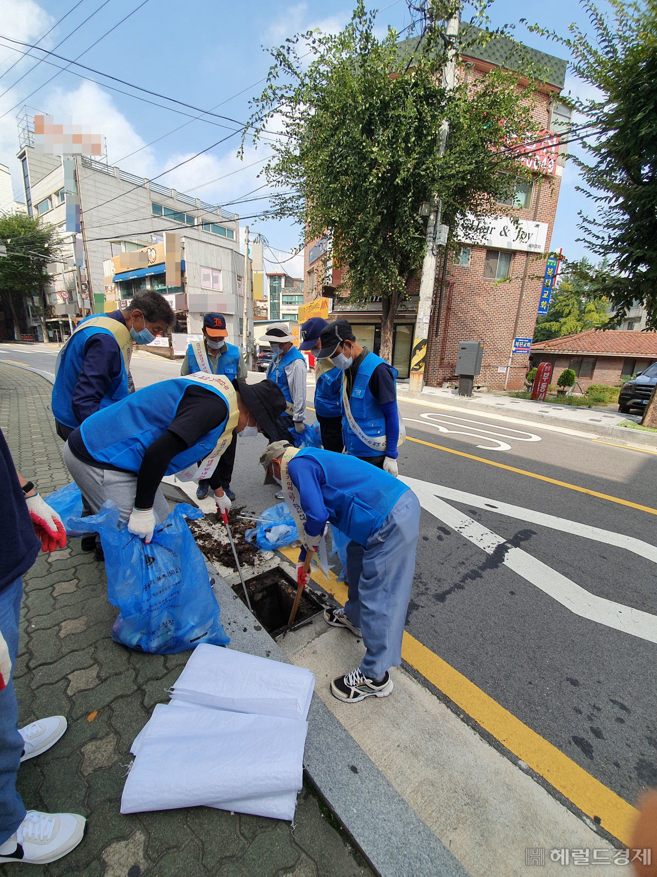 올 하반기 안심일자리 사업 참여자가 도로 배수구에 빠진 담배꽁초를 줍고 있다. [강북구 제공]
