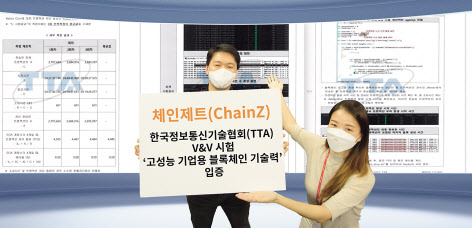 SK㈜ C&C 직원들이 블록체인 플랫폼 ‘체인제트’의 TTA 시험 평가서를 배경으로 기념 촬영을 하고 있다. [SK㈜ C&C 제공]