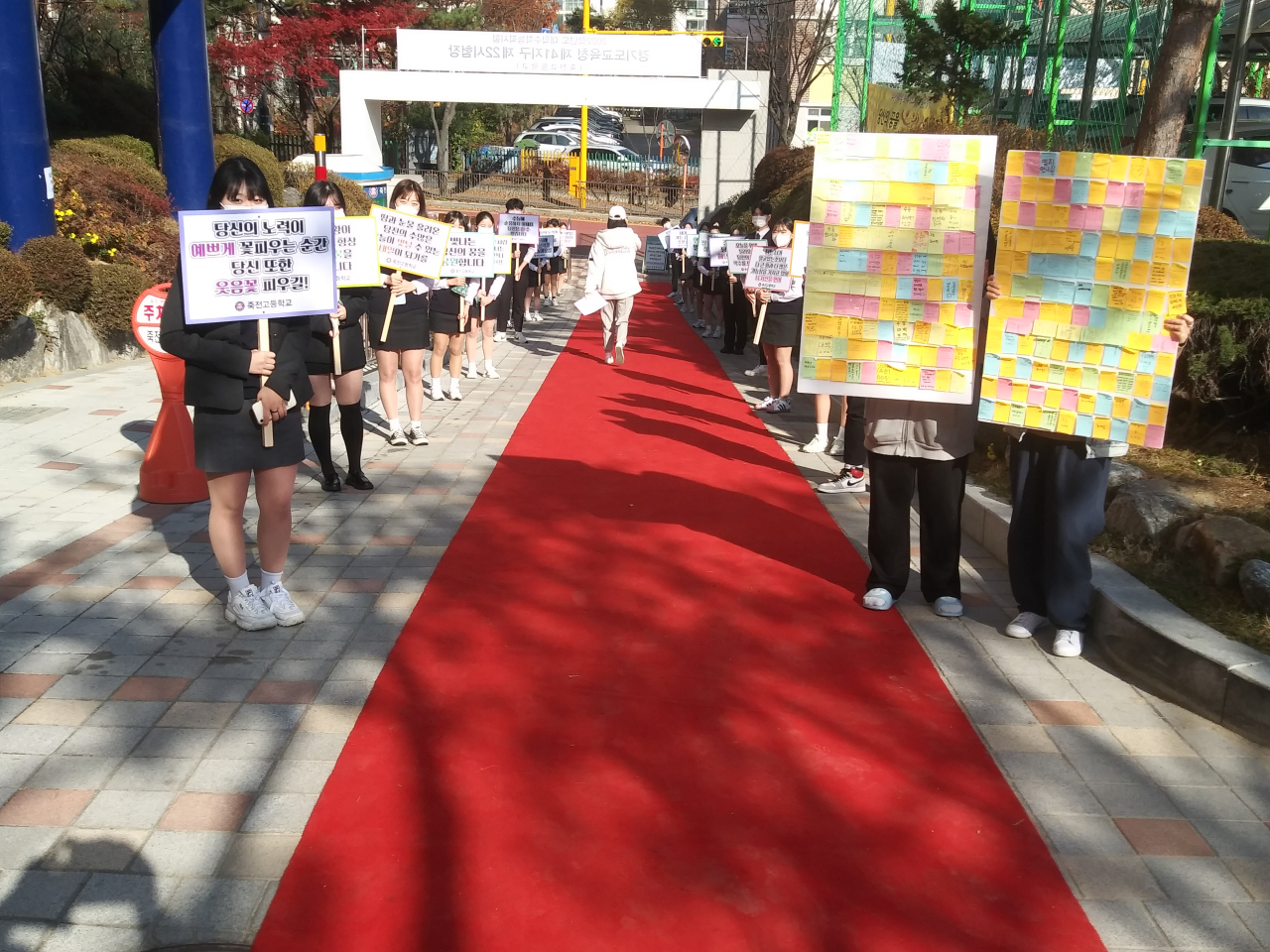 대학수학능력시험 하루 전인 17일 용인 죽전고 정문 진입로에 학생회가 준비한 '레드카펫' 위로 수험생이 수험표를 들고 학교를 나서고 있다. 죽전고 학생회는 수능시험을 앞둔 선배를 응원하기 위해 카펫을 깔고 응원 피켓을 만들어 준비했다. [죽전고 제공]