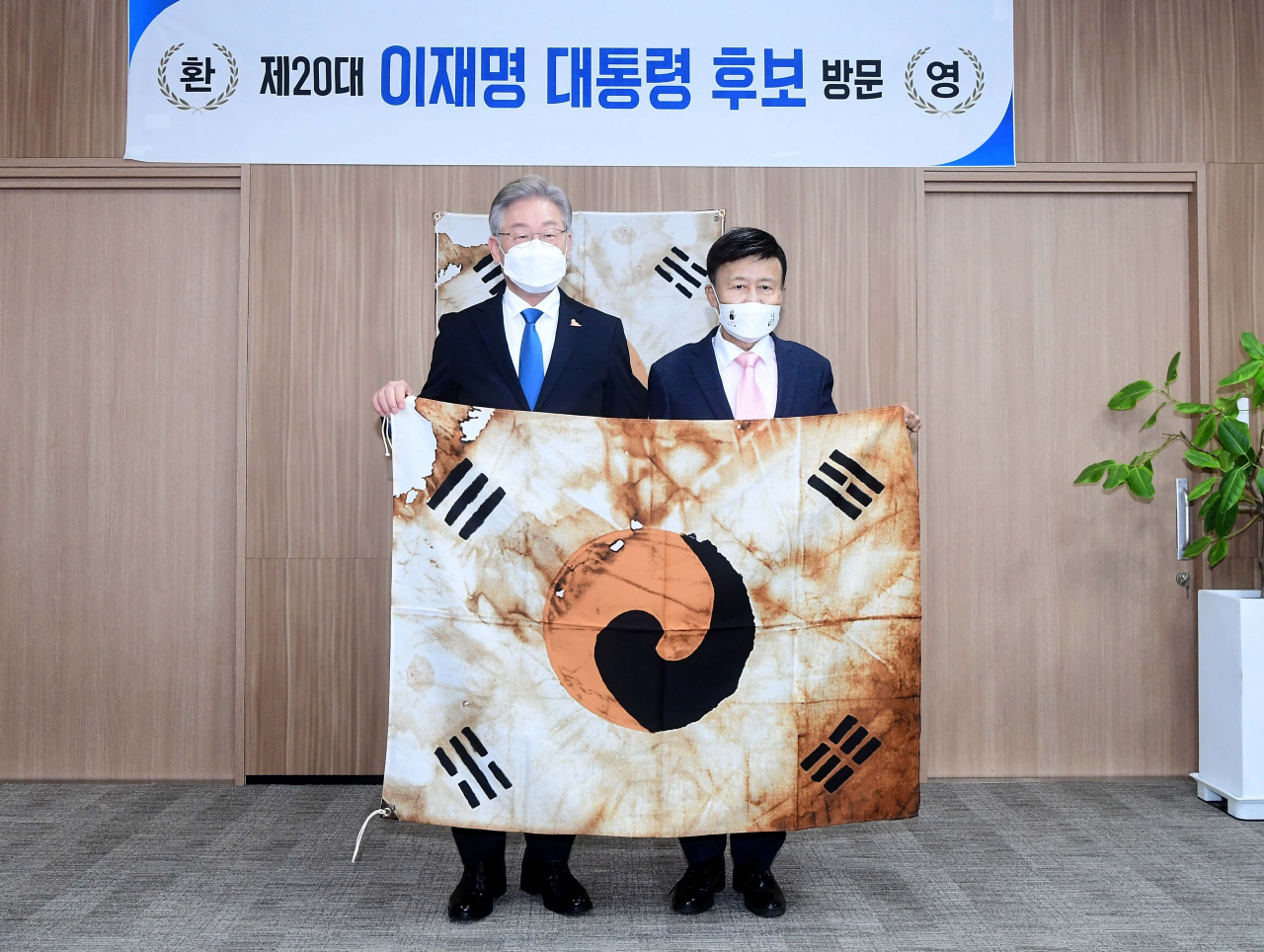 이재명 더불어민주당 대선후보(왼쪽)가 지난 1일 서울 여의도 광복회관을 방문, 김원웅 광복회장과 함께 진관사 태극기를 들고 기념촬영을 하고 있다. [연합]