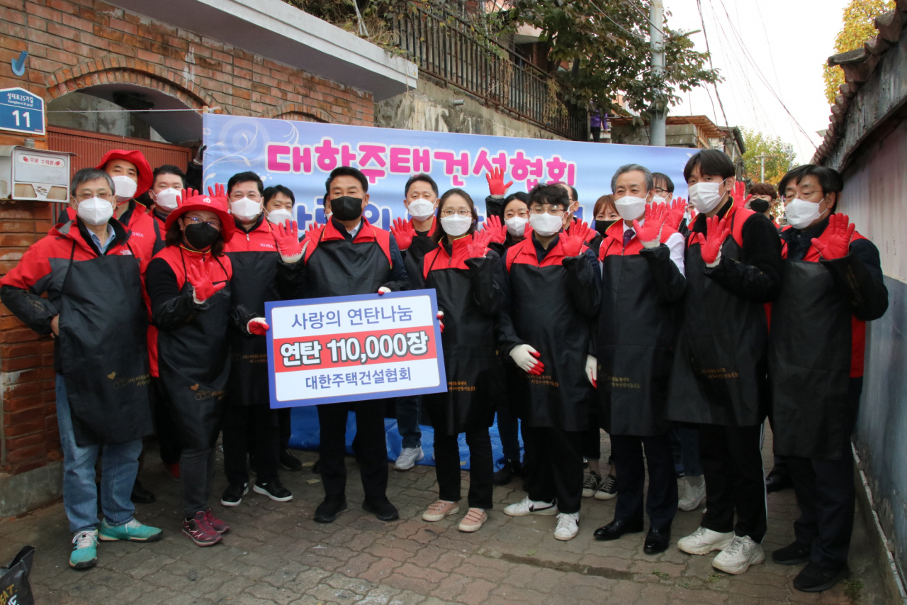 대한주택건설협회가 ‘2021년 사랑의 연탄나눔 봉사활동’을 펼쳤다. 박재홍 회장(앞줄 왼쪽 세번째) 등 임직원들이 지난 17일 서울 동작구 성대로25가길 일대에서 에너지 취약가구에 연탄을 전달한 뒤 기념촬영을 하고 있다. [주건협 제공]