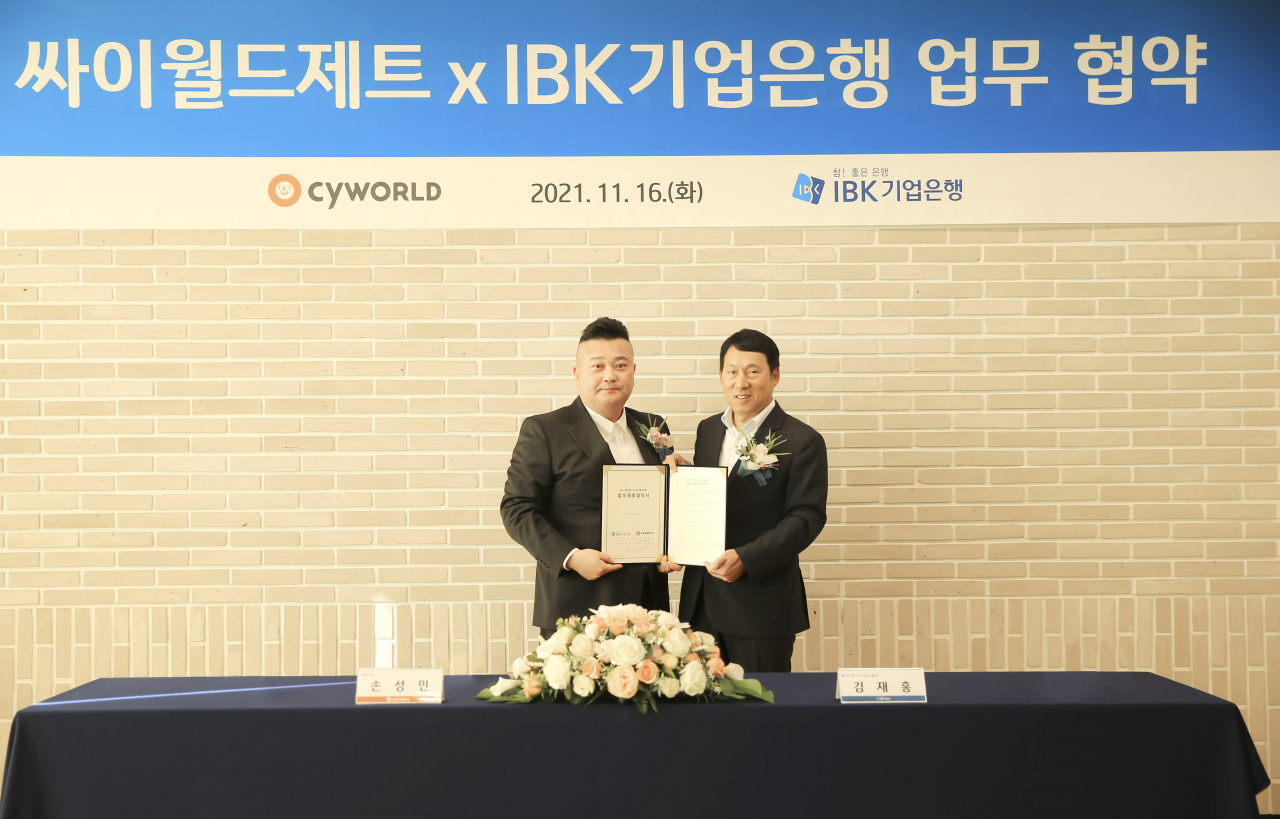 지난 16일 서울 을지로 IBK파이낸스타워에서 김재홍 IBK기업은행 개인고객‧카드사업그룹 부행장(오른쪽)과 손성민 싸이월드제트 대표가 협약식을 마치고 기념촬영을 하고 있는 모습.