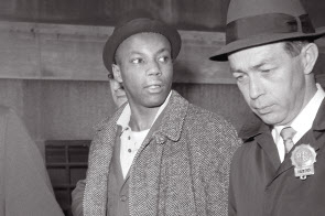 흑인운동 지도자 맬컴 X를 암살한 혐의로 종신형을 선고 받았던 무하마드 아지즈가 1965년 체포된 직후 미국 뉴욕 경찰서에서 나가고 있는 모습. [AP]