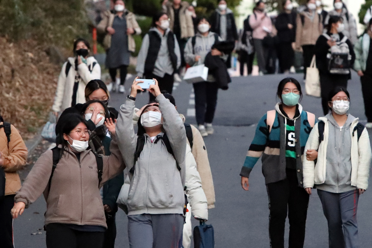 18일 오후 광주 남구 동아여자고등학교 고사장에서 2022학년도 대학수학능력시험을 마친 수험생이 친구들과 휴대전화로 기념사진을 찍고 있다. [연합]