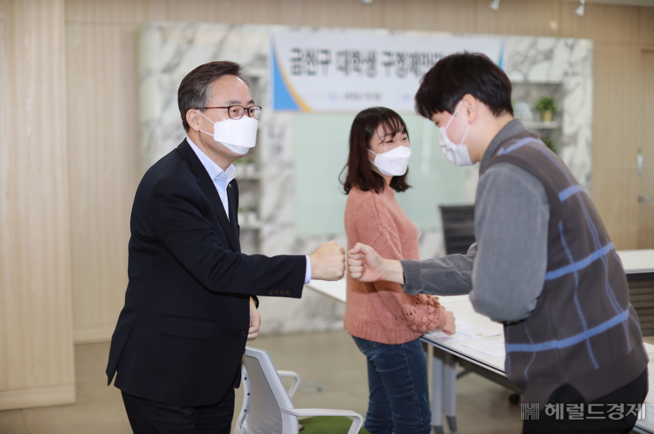 유성훈 구청장이 구청서 부업 일을 하는 대학생과 주먹 인사를 하고 있다. [금천구 제공]