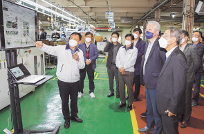 권봉석 LG전자 대표이사 (앞줄 오른쪽에서 두 번째)이 18일 우수협력사 가운데 한 곳인 신성델타테크를 직접 방문해 상패와 포상금을 전달한 후 생산라인을 살펴보고 있다. [LG전자 제공]