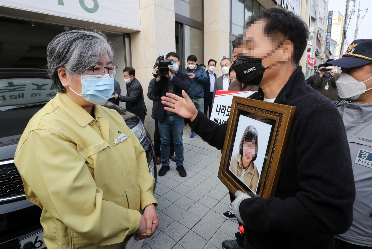 코로나19백신피해자가족협의회(코백회) 회원들이 19일 충북 예방접종 위탁의료기관인 청주시 하나병원 앞에서 추가접종을 하고 병원을 나서는 정은경 질병관리청장을 만나 면담을 요구하고 있다. [연합]
