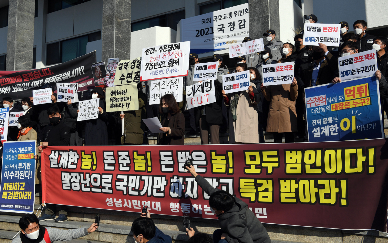 지난달 경기도 수원시 경기도청 앞에서 시민단체 등이 성남 대장동 게이트 관련 손팻말을 들고 특검을 촉구하고 있는 모습. [국회사진기자단]
