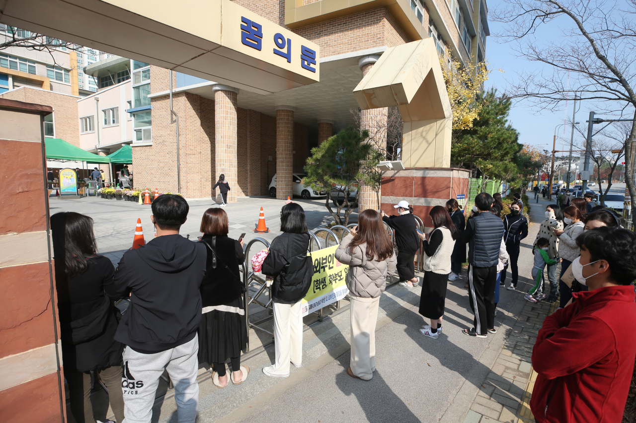 19일 오후 광주 광산구 한 초등학교에서 학부모들이 전수검사를 받고 귀가하는 아이들을 기다리고 있다. 광주에선 이 학교를 포함해 각급 학교에서 확진자가 잇따르고 있다. 연합뉴스