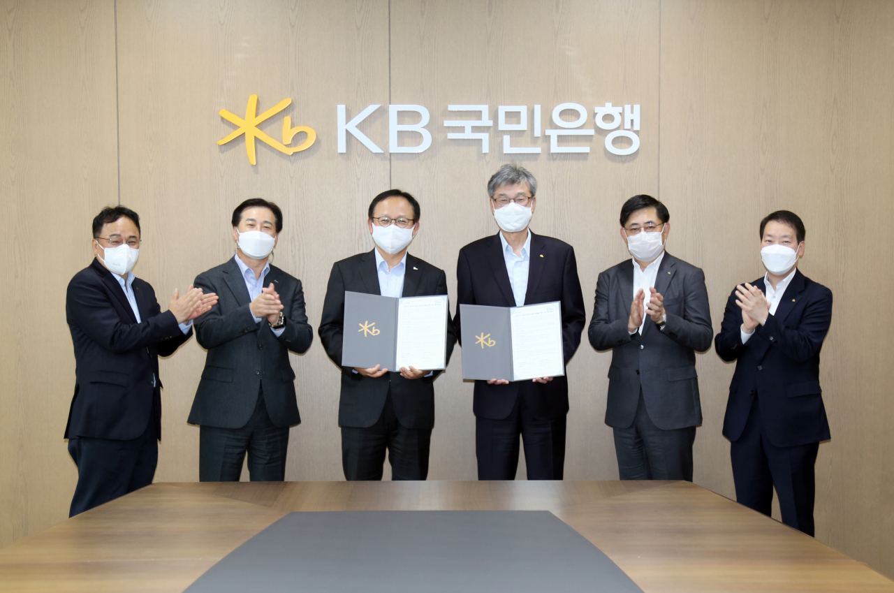 포스코에너지와 KB국민은행은 19일 여의도 KB국민은행 신관에서 ‘ESG 가치 이행 및 RE100 성공적 실행을 위한 MOU’를 체결했다. 가운데 왼쪽 정기섭 포스코에너지 사장, 오른쪽 허인 KB국민은행장. [포스코에너지 제공]