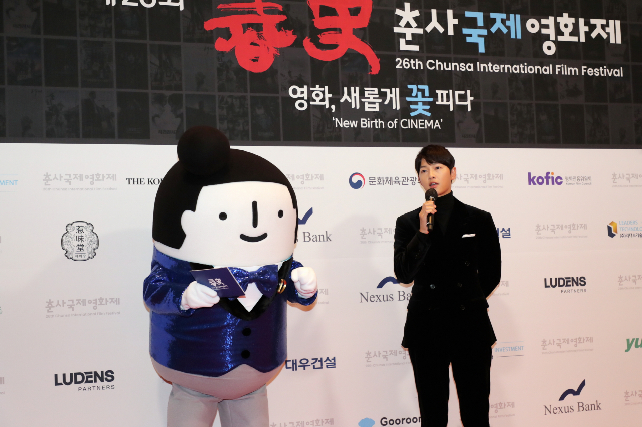 대우건설 캐릭터 홍보대사 '정대우 과장'이 지난 19일 열린 제26회 춘사영화제에서 레드카펫 MC로 배우 송중기와 인터뷰하고 있다. [대우건설 제공]