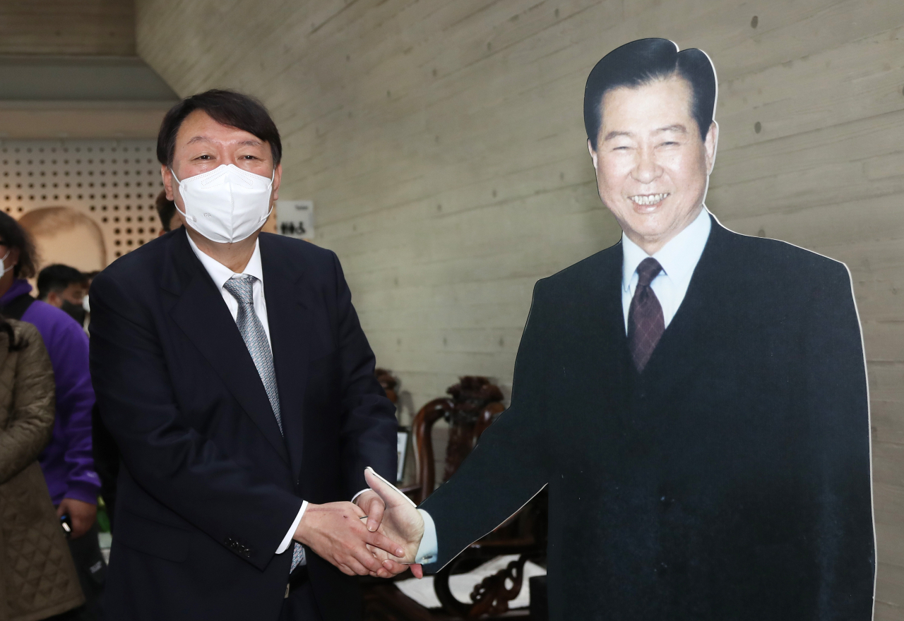 국민의힘 윤석열 대선 후보가 지난 11일 오전 전남 목포시 김대중 노벨평화상기념관를 방문, 김 전 대통령의 1대1 크기 사진과 악수하는 포즈를 취하고 있다. [연합]