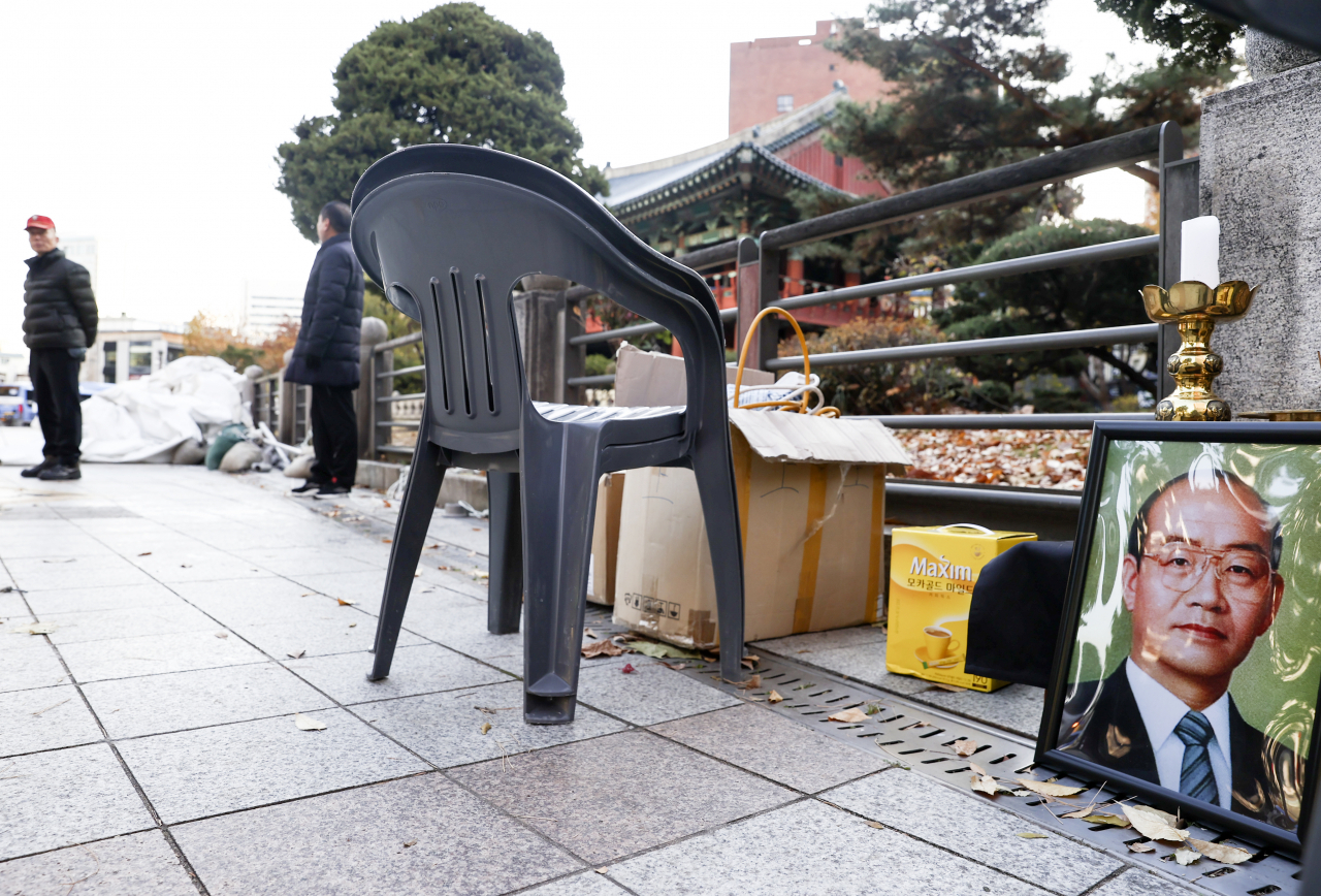 24일 오전 서울 종로구 보신각 앞에 철거된 후 남은 전두환 전 대통령 영정 사진이 놓여 있다. 보수 성향 단체인 태극기혁명국민운동본부(국본)는 이날 새벽에 전 전 대통령 추모 분향소를 설치했다. [연합]