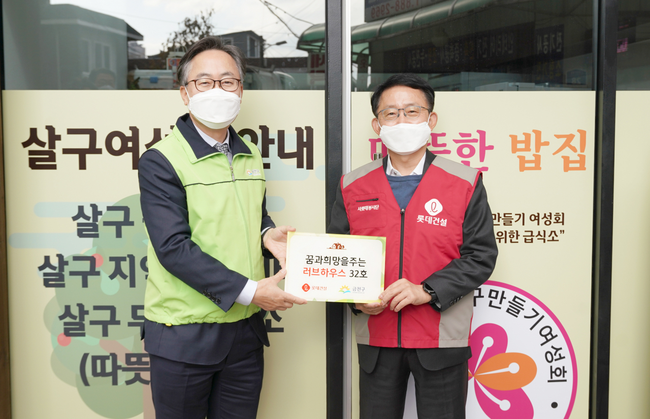 유성훈 금천구청장(사진 왼쪽)과 롯데건설 하석주 대표이사(사진 오른쪽)가 함께 기증판을 전달하고 있다.