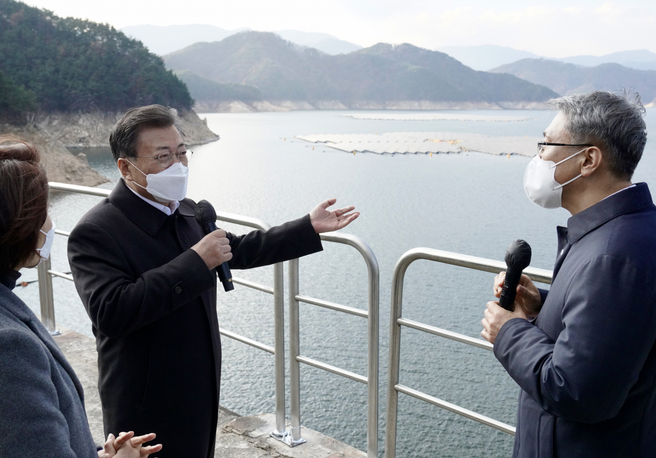문재인 대통령이 24일 상업발전을 시작한 경남 합천군 합천댐 수상태양광(41MW) 현장을 찾아 박재현 한국수자원공사 사장에게 현황 보고를 받고 질문하고 있다. 댐 호수를 이용한 국내 최대 규모의 부유식 합천댐 수상태양광이 매년 생산하는 전력량은 연간 2만가구에서 사용할 수 있는 수준이다. 연합뉴스