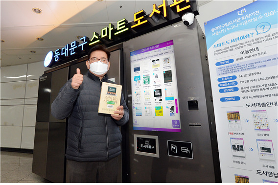 유덕열 동대문 구청장이 용두역에 설치된 스마트 도서관을 방문해 도서를 대여하고 있다. [동대문구 제공]