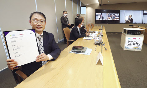 지난 25일 오후 화상으로 진행된 SCFA 총회에 참석한 KT 구현모 대표가 협약서에 서명 후 기념 촬영하고 있다. [KT 제공]