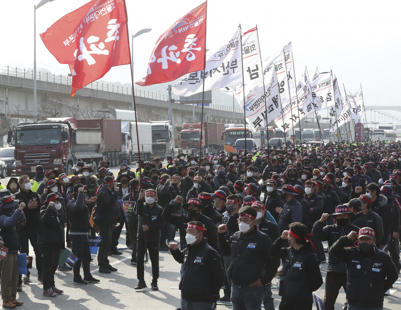 민주노총 공공운수노조 화물연대본부 부산지부 조합원들이 25일 오전 부산 강서구 부산신항 삼거리에서 ‘화물연대 총파업’ 출정식을 열고 있다. [연합]