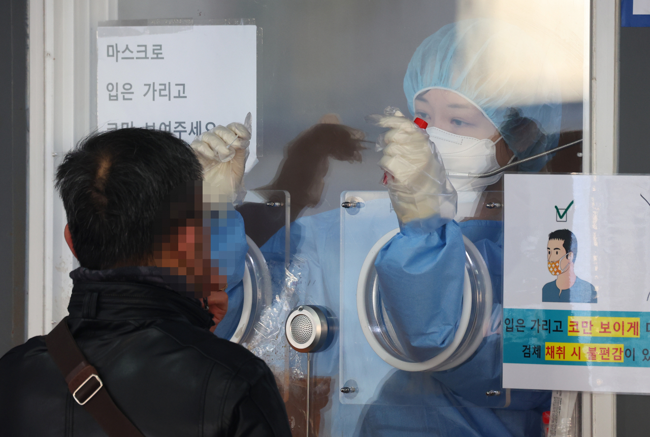 지난 26일 서울역광장에 마련된 코로나19 임시선별검사소를 찾은 시민이 검체 검사를 받고 있다. [연합]