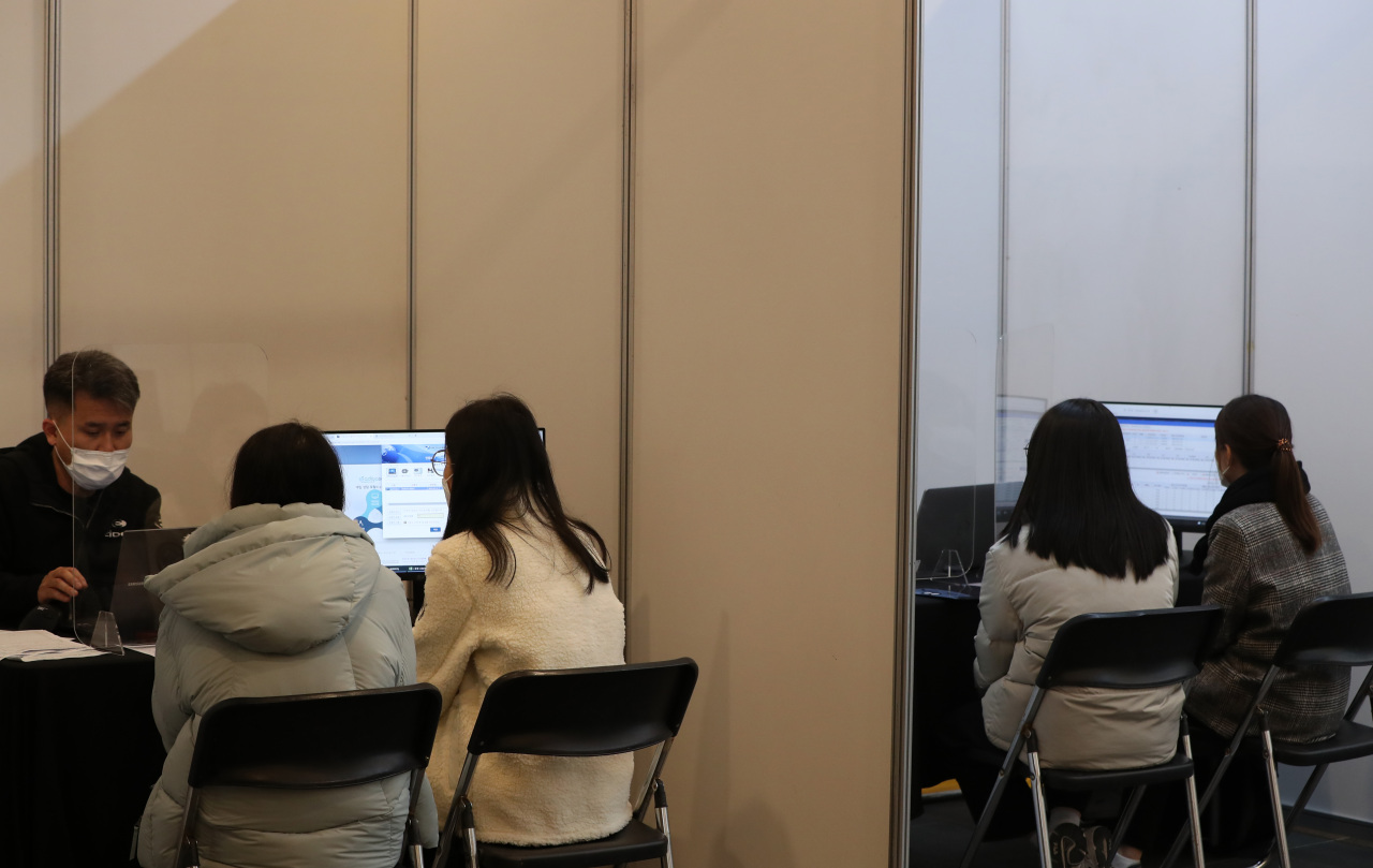 Test takers and their parents are discussing university entrance strategies at a college fair held at Chuncheon City Hall in Gangwon Province on Nov. 21. (Yonhap)
