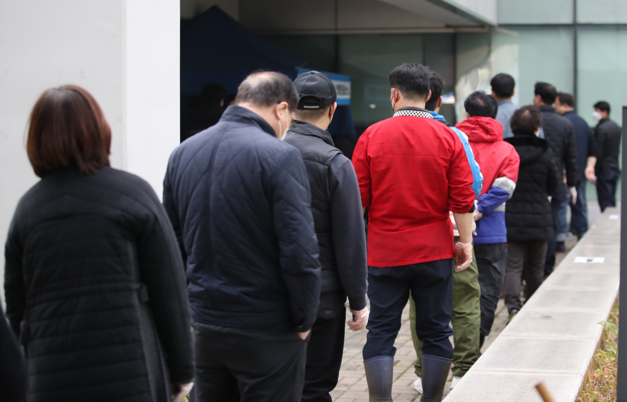 29일 서울 동작구 노량진수산시장 주차장에 설치된 '서울시 찾아가는 선별진료소'에서 상인들이 검사를 기다리고 있다. [연합]