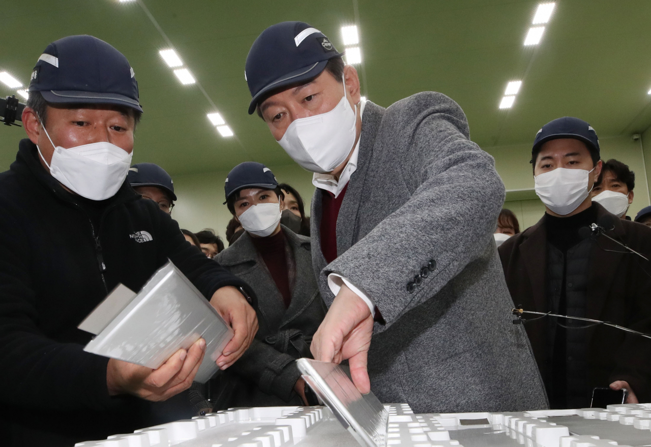 윤석열(가운데) 국민의힘 대선 후보가 30일 오후 충북 청주시 청원구에 있는 우수 강소기업 클레버를 방문해 관계자와 전기차용 2차전지를 살펴보고 있다. [연합]