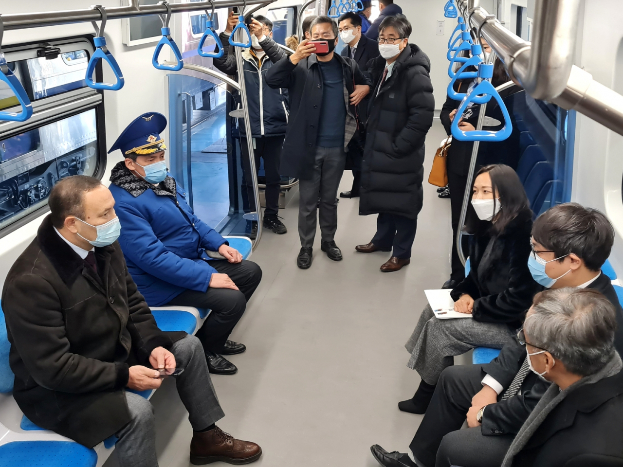 쿠사이노프 세릭 알마티시 부시장(왼쪽 첫 번째)과 텔리바예프 사근득 알마티 메트로 사장(왼쪽 두 번째)이 현대로템이 납품한 전동차에 시승하고 있다. [현대로템 제공]