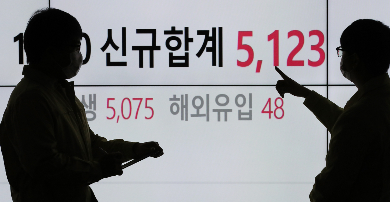신종 코로나바이러스 감염증 국내 신규 확진자가 5123명으로 역대 최초로 5000명대를 넘어선 1일 서울 송파구청 코로나19 확진자 현황판 앞에서 구청 관계자들이 대화하고 있다. 서울에서도 역시 신규 확진자가 2222명으로 역대 최초로 2000명을 넘어섰다. [연합]