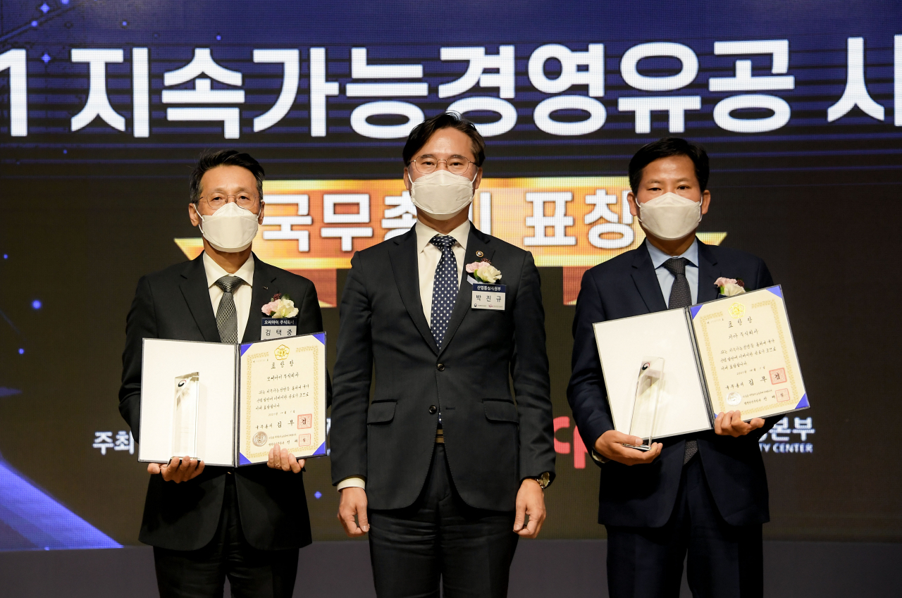 기아 김상대 기업전략실장(오른쪽)이 ‘2021 지속가능경영유공 정부포상’ 국무총리 표창을 수상하고 산업통상자원부 박진규 차관(가운데)과 기념 촬영을 하고 있다. [기아 제공]