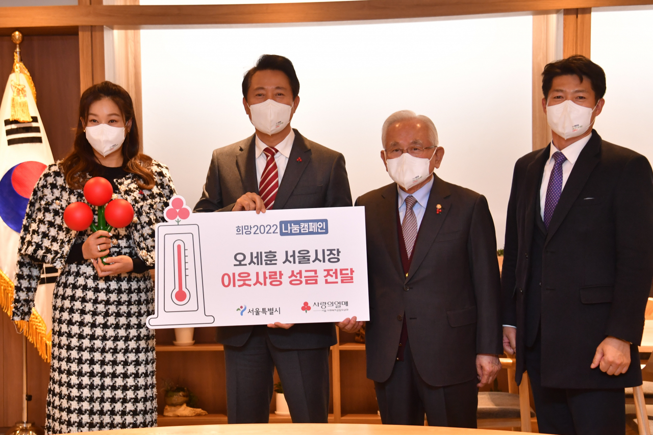 오세훈 시장(가운데)이 사랑의열매에 이웃돕기 성금을 전달하여 홍보대사 방송인 현영(왼쪽)과 서울 사랑의열매 윤영석 회장(오른쪽에서 두 번째), 서울 사랑의열매 김진곤 사무처장(오른쪽)과 함께 기념사진을 찍는 모습