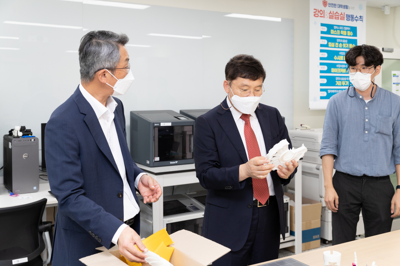 윤상흠 한국디자인진흥원장(오른쪽)이 신기술융합디자인 인력양성사업 참여 대학인 한국산업기술대를 방문해 시제품을 살펴보고 있다. [KIDP 제공]