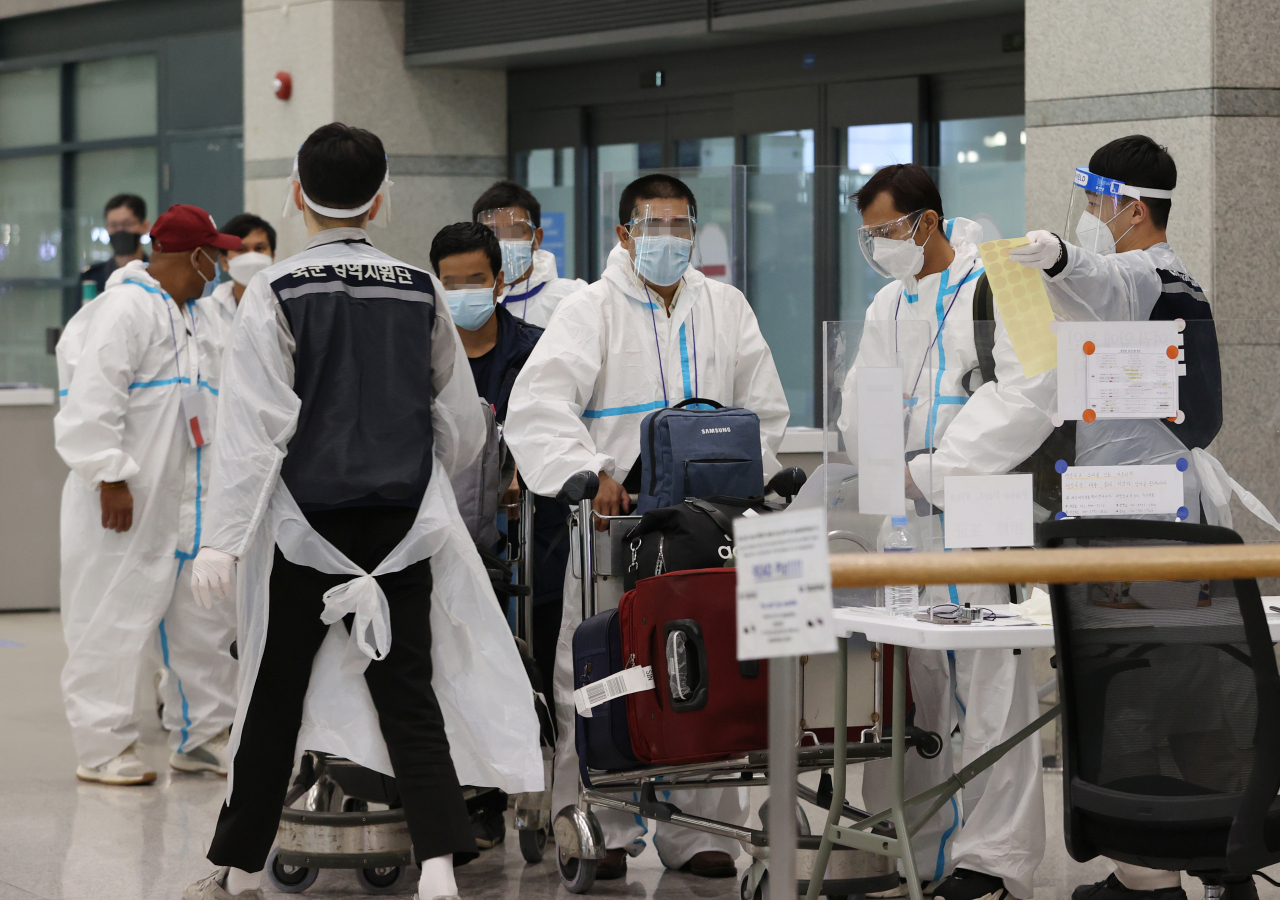 국내에서 신종 코로나바이러스 감염증(코로나19)의 새로운 변이 바이러스인 '오미크론 변이'에 감염된 사례가 확인된 가운데 2일 오전 인천국제공항을 통해 입국한 외국인들이 방역복을 착용한 채 입국장을 나서고 있다. [연합]