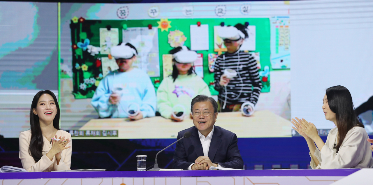 문재인 대통령이 2일 서울 마포구 상암동 누리꿈스퀘어에서 열린 디지털 대한민국 '청년과 함께 미래를 그리다' 행사에 참석, 메타버스를 통해 가상 경주 여행을 한 충남 녹도 초등학생들이 여행이 재밌었다며 하트를 날리자 환하게 웃고 있다. 연합뉴스