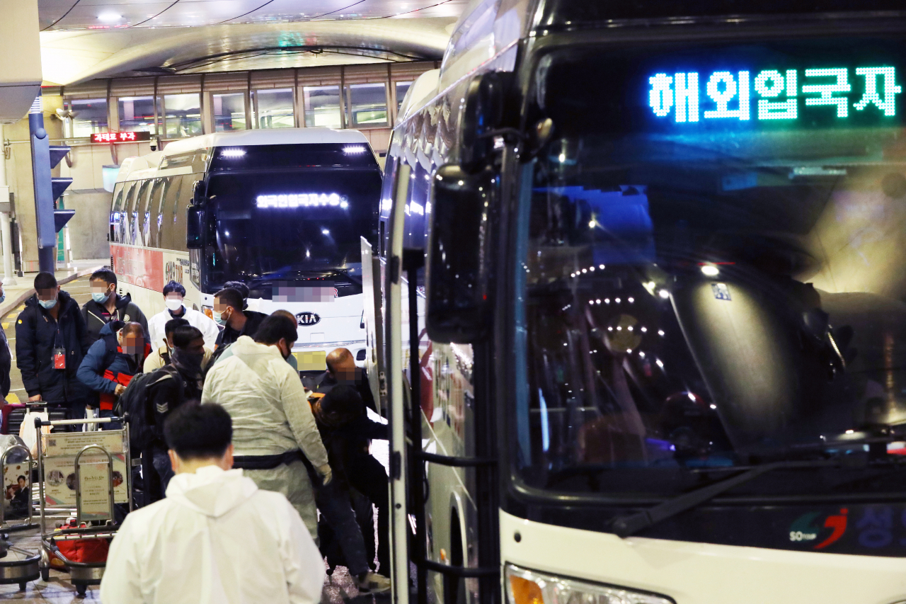 2일 오후 인천국제공항 제1터미널에서 해외 입국자들이 자가격리를 위해 임시 생활시설행 버스에 탑승하고 있다. 국내에서도 코로나19 변이종인 ‘오미크론’ 확진자가 발생함에 따라 모든 국가에서 입국하는 내외국인은 10일간 격리해야 한다. [연합]