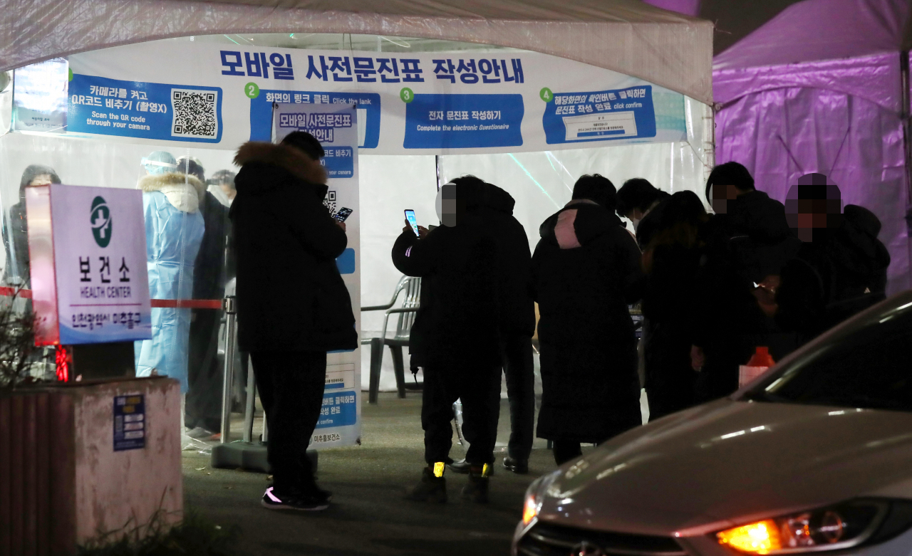 인천 지역에 신종 코로나바이러스 감염증(코로나19)의 새로운 변이 바이러스인 오미크론 변이 확진자가 잇따라 나오는 가운데 지난 2일 밤 인천 미추홀구 미추홀구보건소 선별진료소에 검사자가 줄지어 검사 차례를 기다리고 있다. [연합]