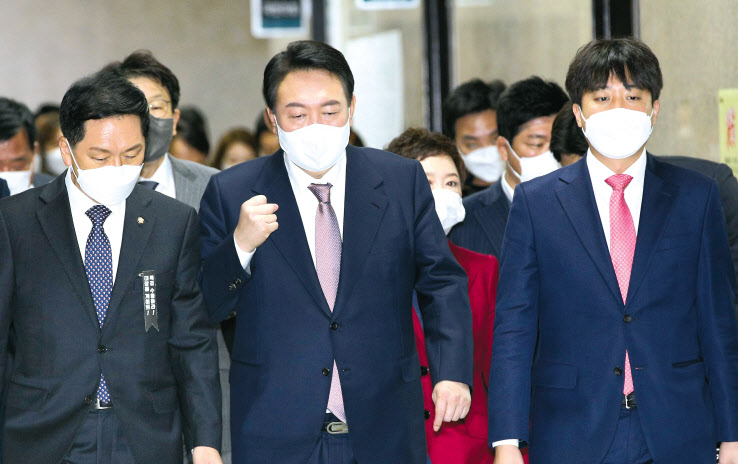 이준석(오른쪽) 국민의힘 대표가 당무를 놓고 지방행을 하기 전인 지난달 25일 윤석열(가운데) 국민의힘 대선 후보와 함께 국회에서 열린 최고위원회의에 참석하고 있다. 이상섭 기자