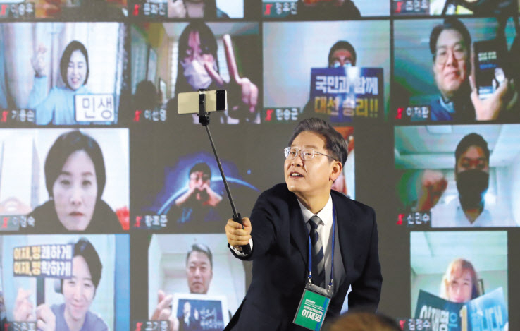 이재명 더불어민주당 대선 후보가 지난달 29일 광주시 서구 김대중컨벤션센터에서 열린 전국민 선대위회의에서 참석자들과 함께 셀카봉으로 직접 기념촬영을 하고 있다. [연합]