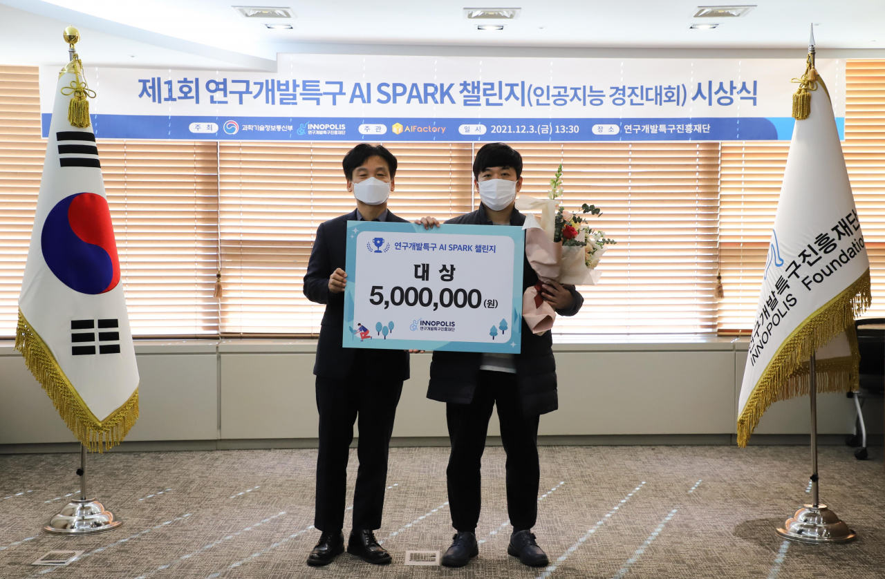 강병삼(왼쪽) 특구진흥재단 이사장과 대상을 수상한 kmu-agent팀 이관수씨가 기념촬영을 하고있다.[특구진흥재단 제공]