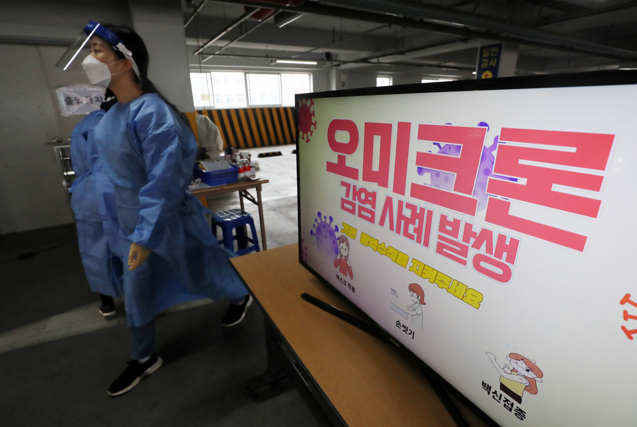 A screen at a screening center for coronavirus tests in the southwestern city of Gwangju on Friday shows a report on the emergence of South Korea's first cases of the new omicron coronavirus variant. (Yonhap)