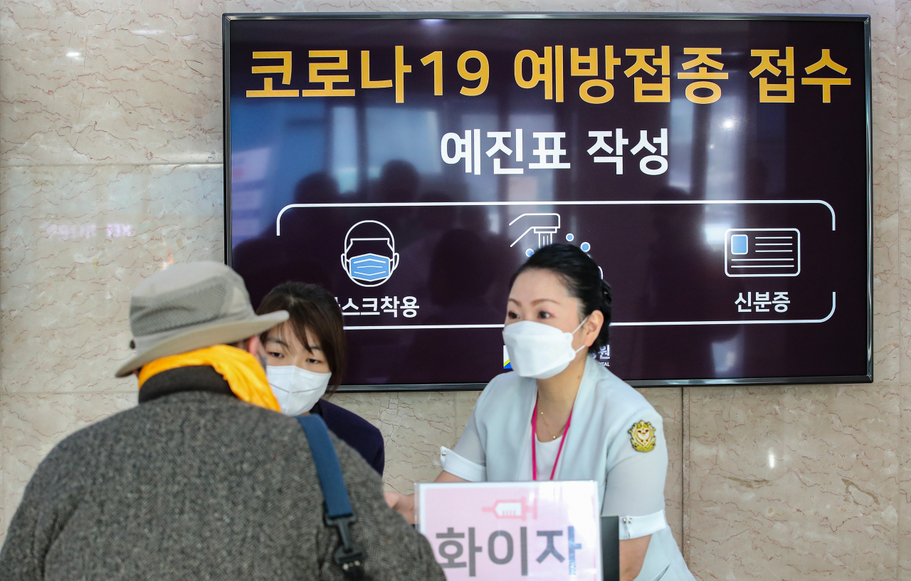 신종 코로나바이러스 감염증(코로나19) 확진자가 연일 최다를 기록하고 변동인 오미크론 국내 확진자도 발생하면서 고령층을 물론 18~49세 접종 완료자의 3차 추가접종(부스터 샷)에 대한 중요성이 증가하고 있는 4일 오전 서울 은평구 청구성심병원에서 백신을 맞기 위해 예약한 시민들이 예진표 작성을 위해 직원의 안내를 받고 있다. [연합]
