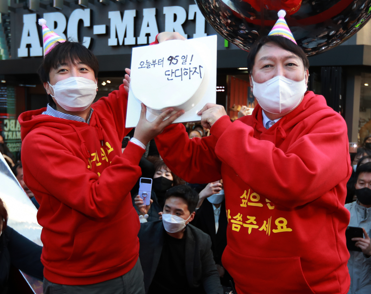 국민의힘 윤석열 대선후보와 이준석 대표가 4일 오후 부산 서면 젊음의 거리에서 윤 후보 생일 케이크를 들고 포즈를 취하고 있다. 생일 케이크에는 '오늘부터 95일 단디하자'라는 문구가 적혀 있다. [연합]