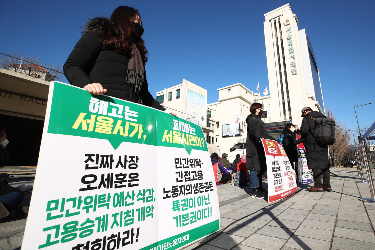 민간위탁노동자공대위 노동자들이 지난 3일 오전 서울 중구 서울시의회 본관 앞에서 열린 오세훈표 반시민·반노동 예산 반대 민간위탁 노동자 결의대회에서 팻말을 들고 있다. [연합]