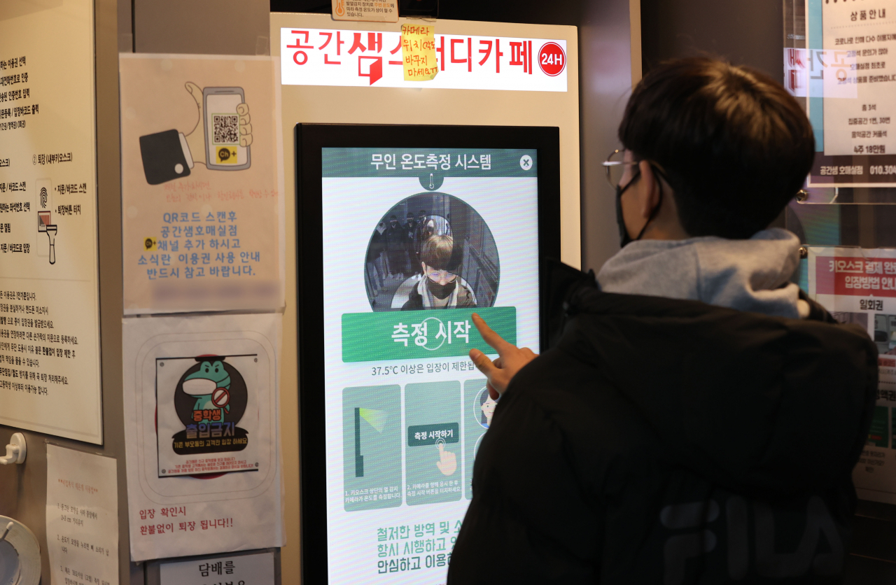 5일 경기 수원 권선구의 한 스터디카페에서 학생들이 입장 전 무인 온도측정 시스템으로 체온을 측정하고 있다.[연합]