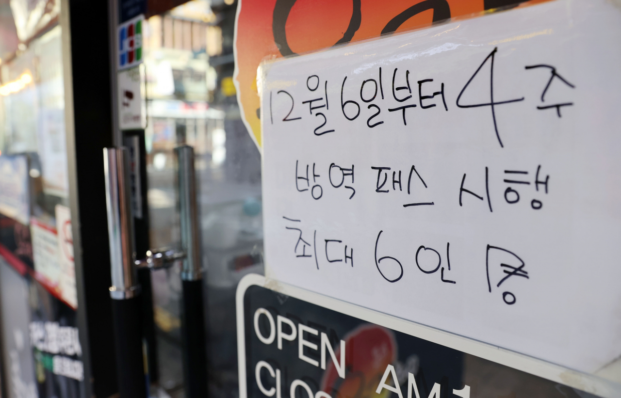 5일 서울 종로구의 한 식당 입구에 방역패스 시행 및 최대 6인 모임 가능 안내문이 붙어 있다. [연합]
