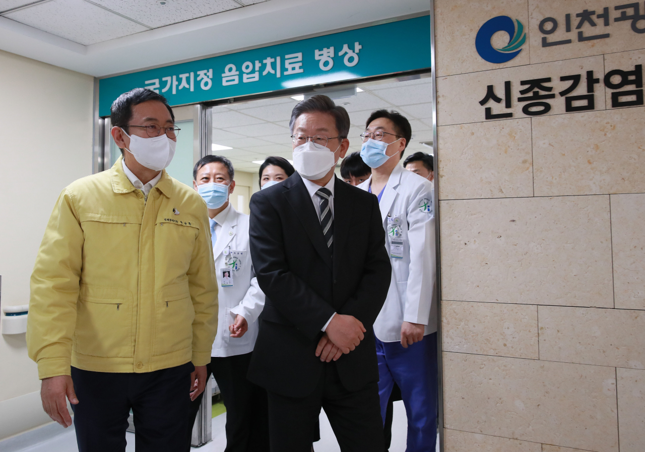 이재명 더불어민주당 대선 후보가 6일 오후 인천시 동구 인천의료원을 찾아 음압병동을 둘러본 뒤 의료진과 이동하고 있다. 왼쪽은 박남춘 인천광역시장. [연합]
