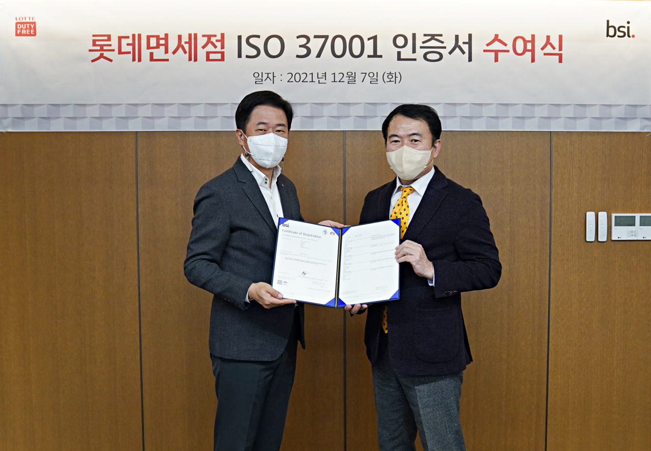 이갑 롯데면세점 대표이사(사진 왼쪽)가 지난 7일 서울 중구 롯데면세점 본사에서 열린 ‘부패방지경영시스템 ISO37001’ 인증을 획득한 후 송경수 BSI KOREA(영국표준협회 한국지사) 대표이사와 기념 촬영을 하고 있다. [롯데면세점 제공]